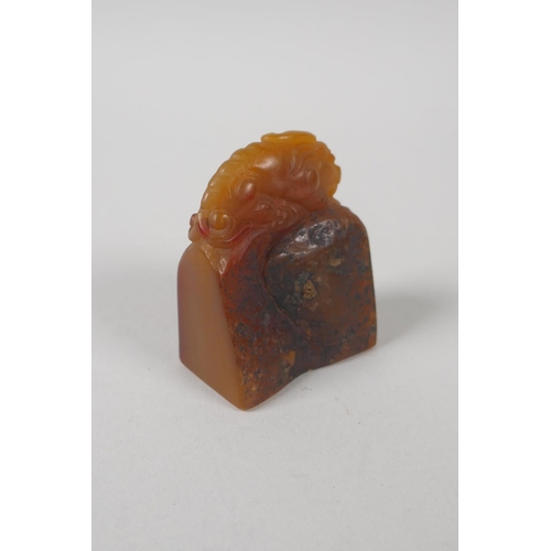 68 - A Chinese amber soapstone carving of a kylin, 6cm high