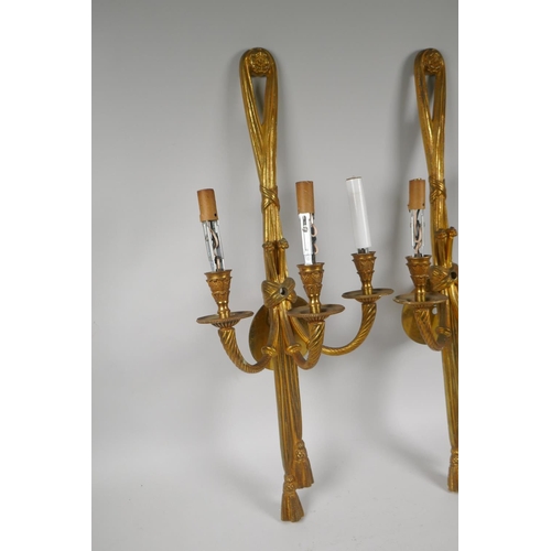 71 - A pair of French style of ormolu three branch wall sconces with rope and tassel decoration, 65cm