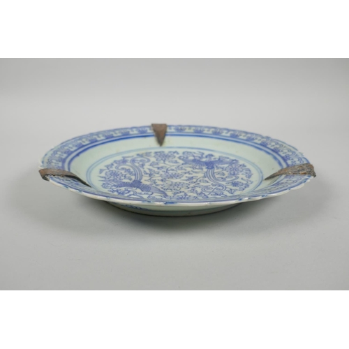 90 - A Chinese late C19th/early C20th blue and white porcelain dish with a lobed rim and phoenix decorati... 