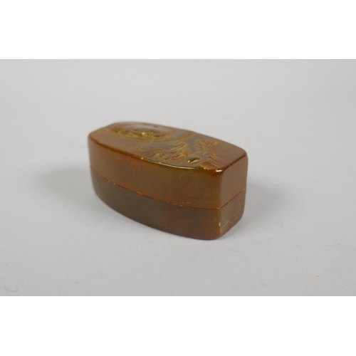 99 - A Chinese amber soapstone seal in a matching soapstone box, with carved Buddha decoration to cover, ... 