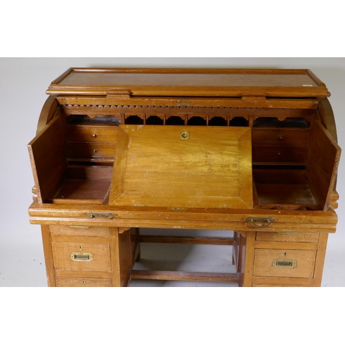 1018 - A C19th colonial teak cylinder top desk, the interior fitted with pigeon holes and six drawers, and ... 