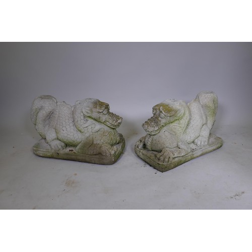 1081 - A pair of reconstituted stone dragons signed Helen Young, 54 x 34cm