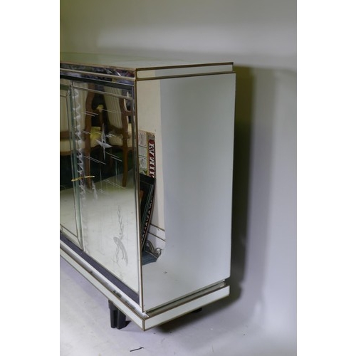 1131 - A mid century mirror glassed side cabinet, with brass mounts and stepped top over a sectional glass ... 