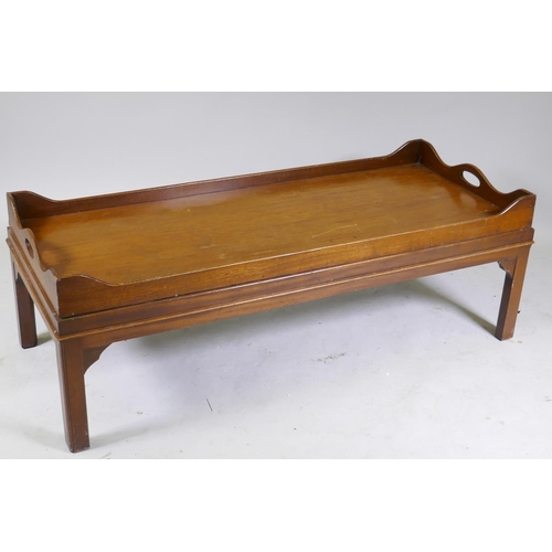 1125 - A mahogany tray top occasional table raised on square chamfered supports, 124 x 52 x 42cm