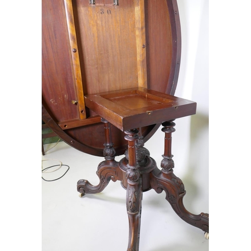 1002 - A good Victorian burr walnut loo/centre table with tilt top, raised on four carved columns on cabrio... 