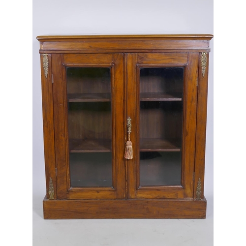 1012 - Victorian walnut pier cabinet with brass mounts and two glazed doors, raised on a plinth base, 82 x ... 