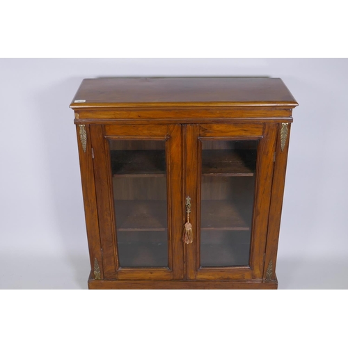 1012 - Victorian walnut pier cabinet with brass mounts and two glazed doors, raised on a plinth base, 82 x ... 