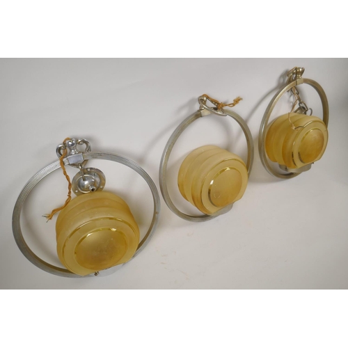 1026 - Three Art Deco chromed metal and glass cafe pendant lights, 30cm diameter