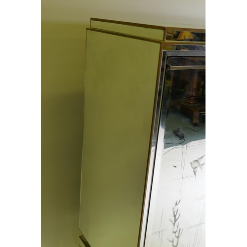 1053 - A mid century mirror glassed side cabinet, with brass mounts and stepped top over a sectional glass ... 