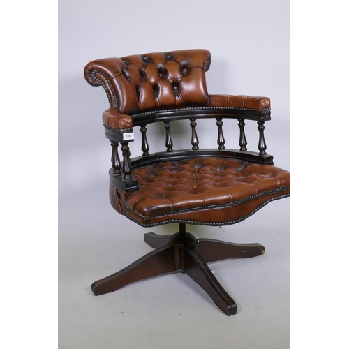 1061 - A tilt and swivel buttoned leather captain's bow armed  desk chair