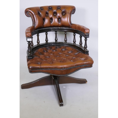 1061 - A tilt and swivel buttoned leather captain's bow armed  desk chair