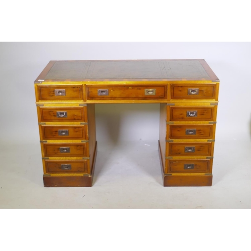 1066 - A yew wood veneered campaign style eleven drawer kneehole desk, with inset leather top and brass mou... 