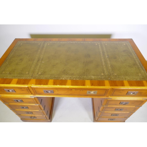 1066 - A yew wood veneered campaign style eleven drawer kneehole desk, with inset leather top and brass mou... 