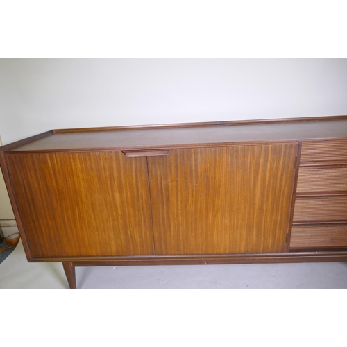 1068 - A mid century Richard Hornby for Heals afromosia side board with four drawers and two cupboards, rai... 