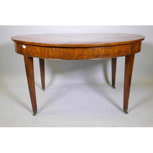 1069 - An antique yew wood oval centre table, with sunburst veneer top, the frieze with brass edge and rais... 