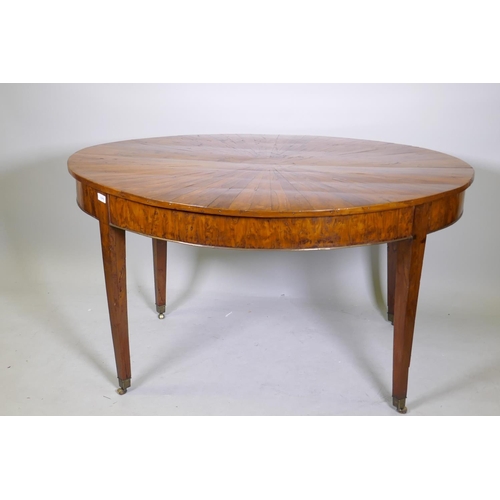 1069 - An antique yew wood oval centre table, with sunburst veneer top, the frieze with brass edge and rais... 