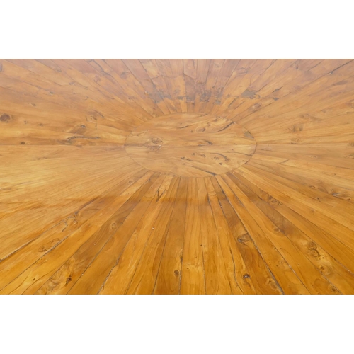 1069 - An antique yew wood oval centre table, with sunburst veneer top, the frieze with brass edge and rais... 