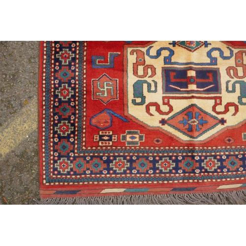 1090 - A Russian terracotta ground Kazak full pile rug with three geometric medallion design, c.1900, 130 x... 