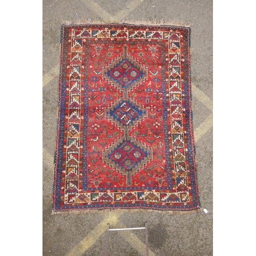 1093 - A C19th Persian red ground Qashqai tribal rug decorated with blue geometric medallion design, surrou... 