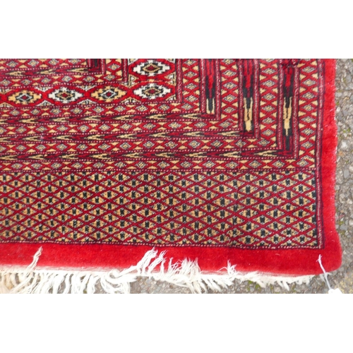 1101 - A Turkman fine red ground Bokhara rug, 290 x 360cm