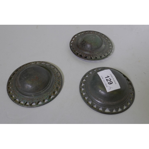 129 - Three Middle Eastern bronze buckles, boss shaped with pierced borders, 9cm diameter