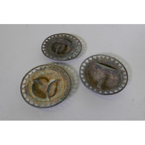 129 - Three Middle Eastern bronze buckles, boss shaped with pierced borders, 9cm diameter