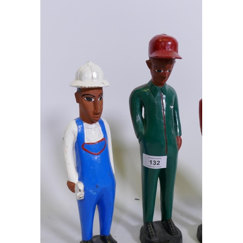 132 - A set of four African Colon carved and painted wood figures of construction workers, 29cm high