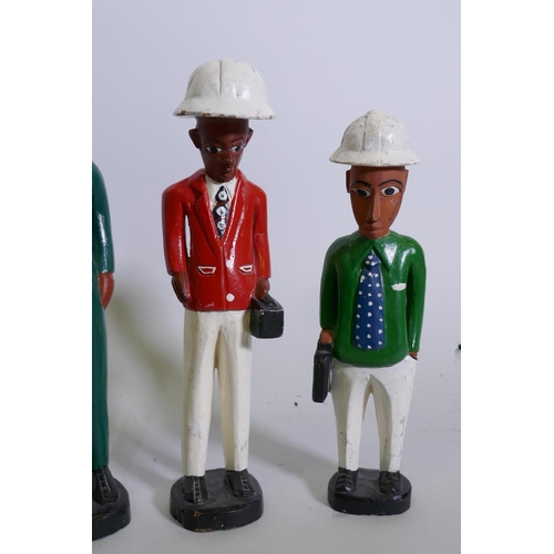 132 - A set of four African Colon carved and painted wood figures of construction workers, 29cm high