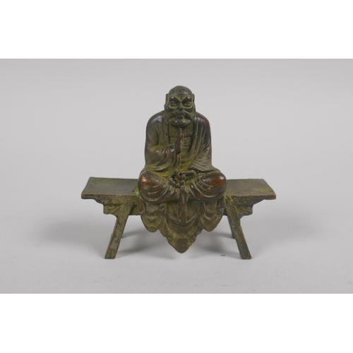 142 - A Chinese bronze figure of Lo-han seated in contemplation, 8cm long