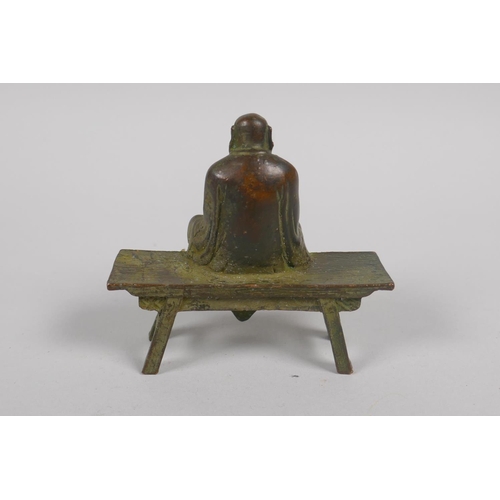 142 - A Chinese bronze figure of Lo-han seated in contemplation, 8cm long