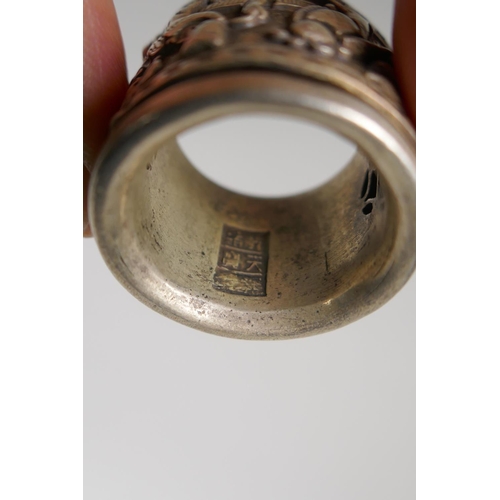 143 - A Chinese white metal archer's thumb ring with decorative figural rotating cuff, and two white metal... 