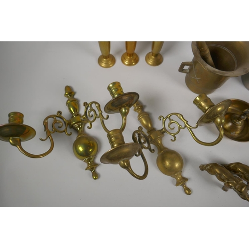 161 - A quantity of antique brass ware to include a pestle and mortar, a pair of two branch candle sconces... 