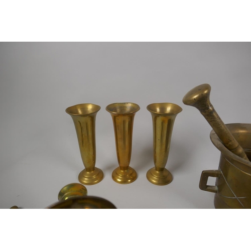 161 - A quantity of antique brass ware to include a pestle and mortar, a pair of two branch candle sconces... 