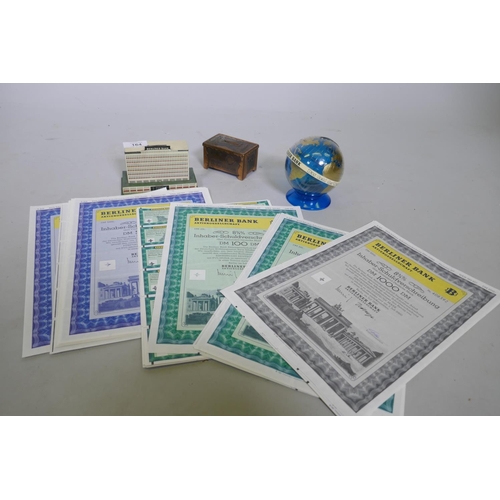 164 - A Berliner Bank tin money box, 13 x 6 x 9cm, two others and a quantity of shares certificates