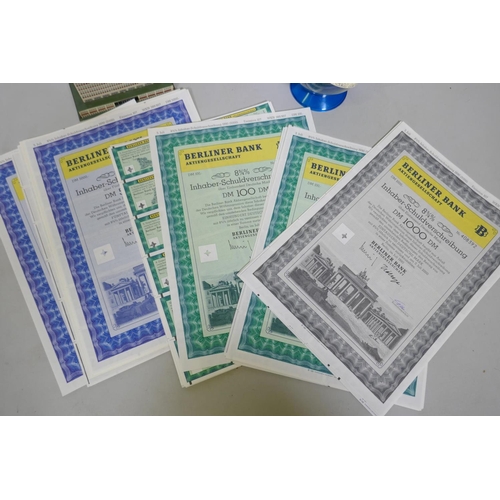 164 - A Berliner Bank tin money box, 13 x 6 x 9cm, two others and a quantity of shares certificates