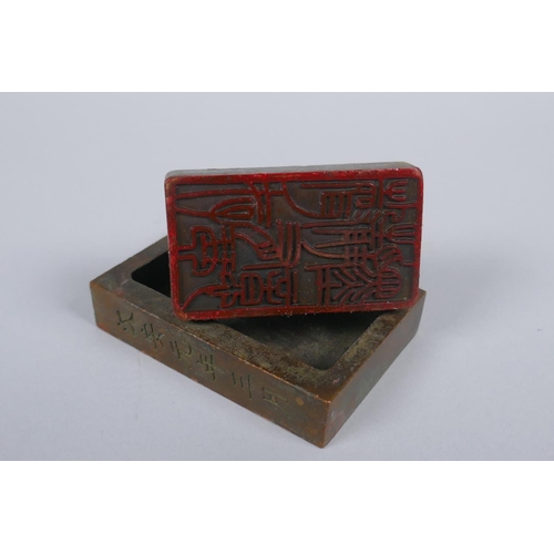 171 - A Chinese bronze twin seal with dragon knop, 8 x 6cm