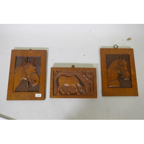 172 - A pair of oak panels carved in low relief with horse's heads, and another of a horse feeding under a... 