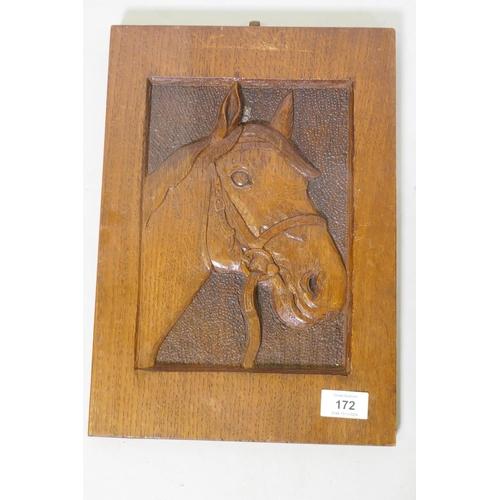 172 - A pair of oak panels carved in low relief with horse's heads, and another of a horse feeding under a... 