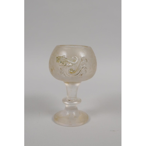 175 - A Chinese molded glass libation cup with twin dragon handles, 11cm high