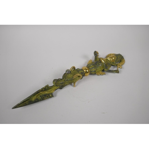 176 - A Tibetan bronze ceremonial phurba with gilt highlights and ganesh shaped handle, 32cm long