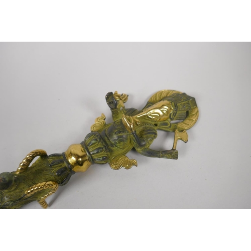 176 - A Tibetan bronze ceremonial phurba with gilt highlights and ganesh shaped handle, 32cm long