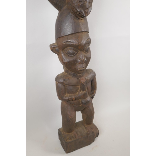 18 - A West African hardwood carving of a leopard over a figure, 95cm high