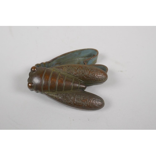 199 - An oriental bronze ink box in the form of a cicada, with character inscription to base, 8cm long