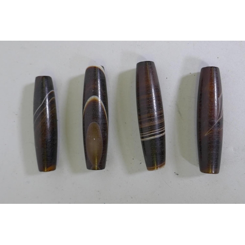 202 - Four agate cylinder shaped beads, 6cm long