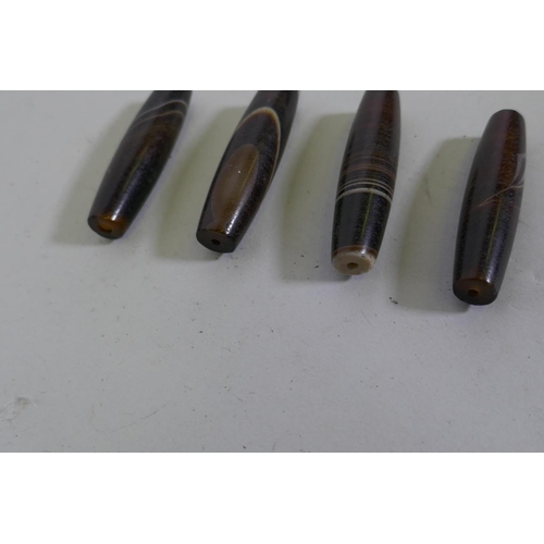 202 - Four agate cylinder shaped beads, 6cm long