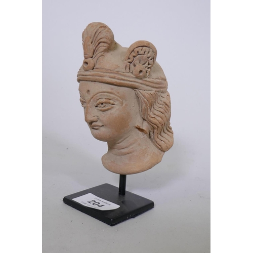 204 - A Gandhara style terracotta head of a woman wearing a headdress, mounted on a metal stand, 16cm high