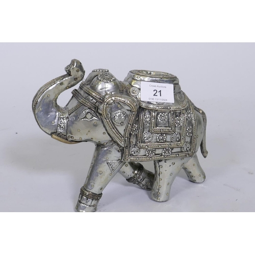 21 - An antique Indian white metal figure of an elephant with brass nail decoration, 17cm high