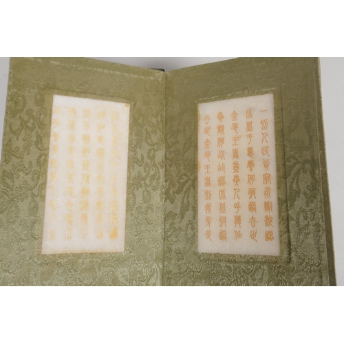 213 - A Chinese wood and silk bound book containing white jade tablet pages bearing chased and gilt inscri... 