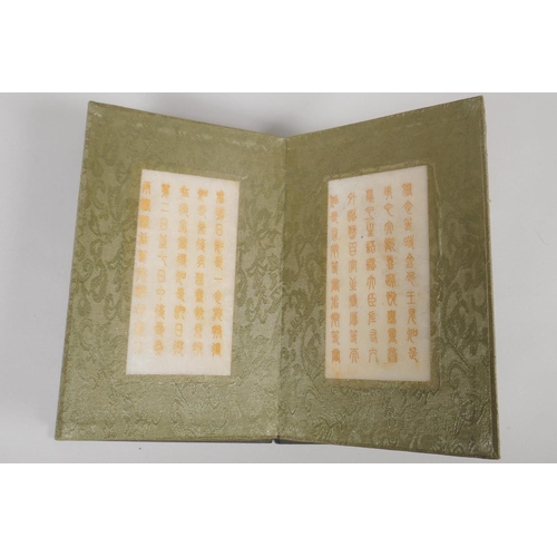 213 - A Chinese wood and silk bound book containing white jade tablet pages bearing chased and gilt inscri... 