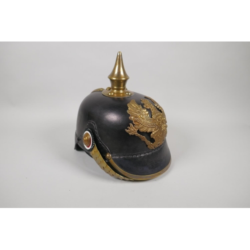 223 - A reproduction German pickelhaube with brass mounts